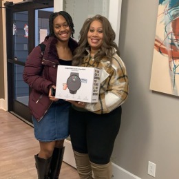 two ladies people for a picture holding a prize