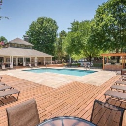 a deck with a pool and lounge chairs